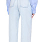A person is seen from the back wearing Anine Bing’s Manon Jean in ultra-bleached blue with a baggy wide-leg fit, two back pockets, and a leather brand patch, paired with a light blue shirt.