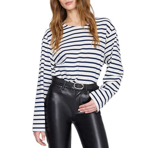 A woman wears the Anine Bing Newton Tee, a navy striped long sleeve shirt with a boat neckline, paired with high-waisted black leather pants and a black belt.