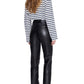 A person stands with their back to the camera, wearing the Anine Bing Newton Tee—a navy striped long sleeve with a boat neckline—paired with black leather pants and black flats.