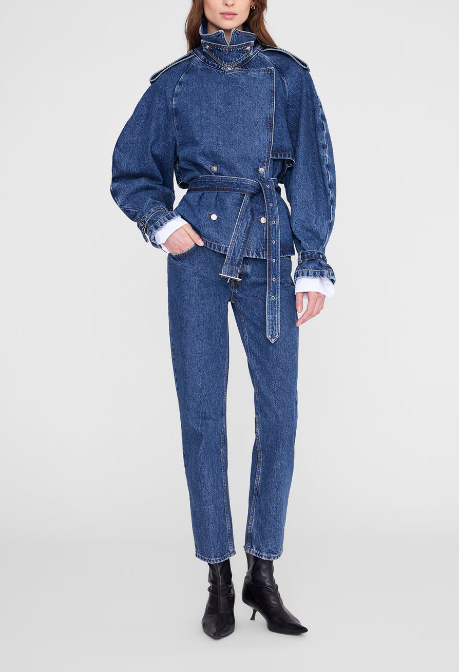 Wearing the Anine Bing Pascale Trench, styled as transitional outerwear, paired with matching denim pants and black heeled boots, this person stands against a plain white background.