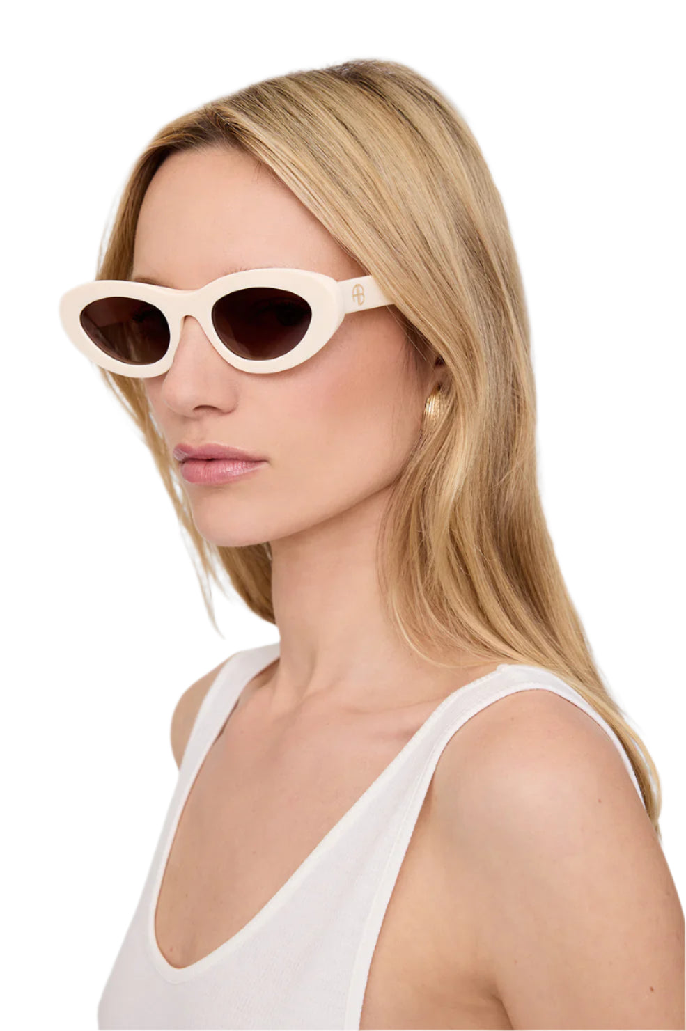 A woman with long blonde hair wears Anine Bing Roma Sunglasses—bone acetate oval frames with brown gradient lenses—and a white tank top, facing left against a plain white background.
