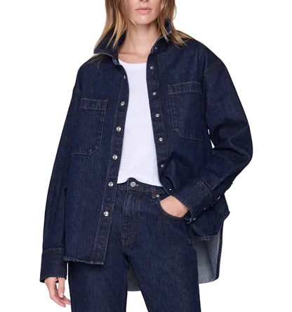 Wearing the Anine Bing Samy Shirt—an oversized dark blue cotton denim canvas shirt—over a white top and matching dark blue denim jeans, with one hand in a pocket.