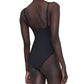 A person is seen from the back, standing with one arm relaxed at their side, wearing the Anine Bing Vesta One Piece—a black minimalist swimsuit with adjustable straps.