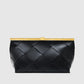 The Anine Bing Anine Braided Leather Clutch features black leather with a bold braided pattern and is topped with a rectangular gold metal frame, creating a sculptural silhouette that makes it a true statement piece, shown against a plain light background.