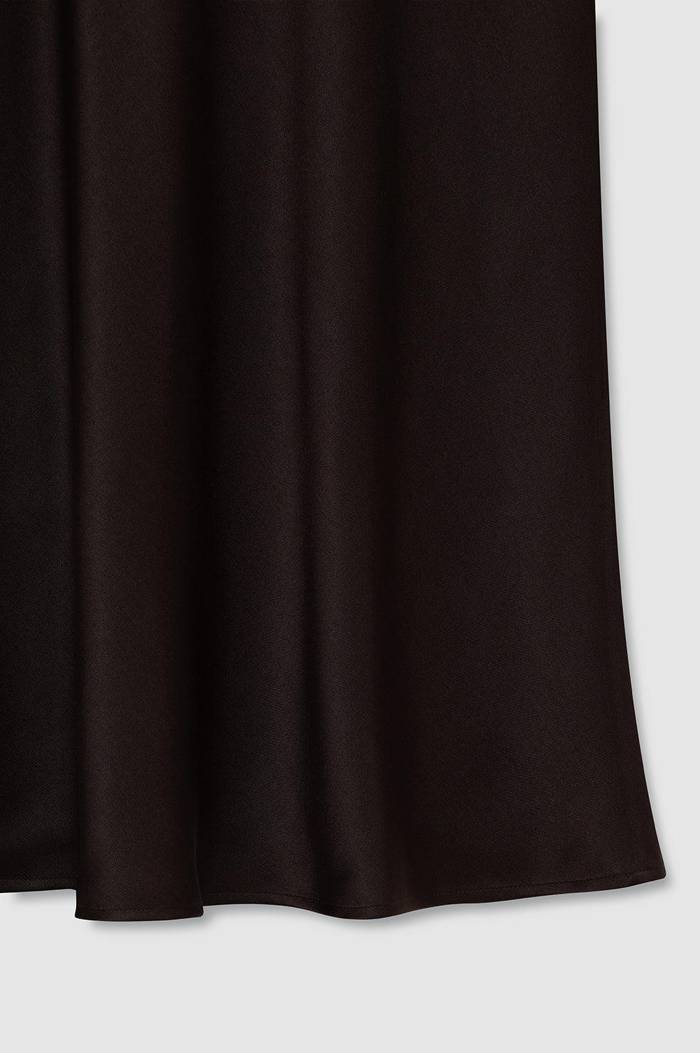 A close-up of the Bar Silk Skirt by Anine Bing, a black high-waisted midi skirt in silk, shown hanging against a light gray background.