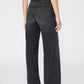 A person is shown from the back wearing Anine Bing's Brie Jean, featuring a high-waisted, wide-leg silhouette in dark wash rigid cotton denim, paired with black heeled shoes against a plain backdrop.