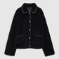 The Camden Jacket by Anine Bing is a black textured wool blend workwear style featuring button closure, two front pockets, and leather-like trim accents on the collar, pockets, cuffs, and hem. It is displayed against a plain light background.