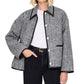 A person wears the Anine Bing Camden Jacket, a black and white plaid wool blend workwear style, over a white shirt with black pants and a black belt, standing against a plain background.
