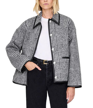 A person wears the Anine Bing Camden Jacket, a black and white plaid wool blend workwear style, over a white shirt with black pants and a black belt, standing against a plain background.