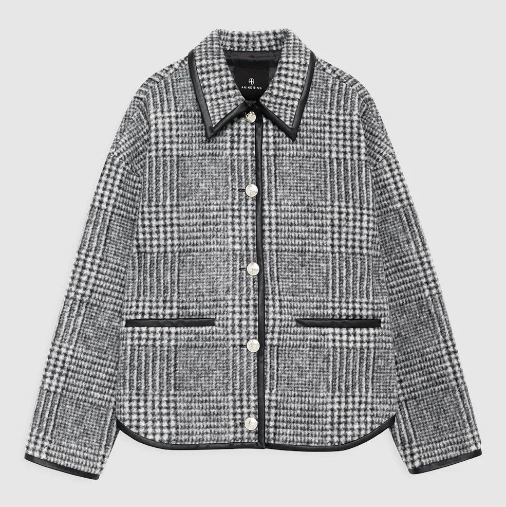 The Camden Jacket by Anine Bing is a men's casual gray and black plaid wool blend jacket with white buttons and black trim on the collar, pockets, and edges, shown on a plain background for a stylish everyday look.