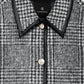 Close-up of the Camden Jacket by Anine Bing: a gray and black houndstooth-patterned wool blend coat with a pointed collar, black trim, and silver buttons.