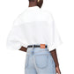 A person is seen from the back wearing the Anine Bing Coco Shirt in ivory, loosely tucked into light blue high-waisted jeans.