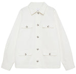 The Corey Jacket by Anine Bing is a white cotton canvas jacket featuring long sleeves, a collar, and four front flap pockets with button closures.