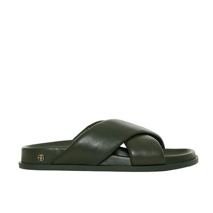 The Emi Slides by Anine Bing are dark green flat sandals featuring wide, overlapping crisscross padded lambskin leather straps and a flat sole, shown in a side profile view.
