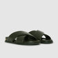 The Anine Bing Emi Slides feature dark green, wide padded crisscross straps and flat soles, shown on a light gray background.