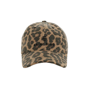 A front view of the Anine Bing Jeremy Leopard Baseball Cap, showcasing its tan and brown leopard print design with black embroidered text and logo on the front panel, featuring an adjustable back strap for a perfect fit, displayed on a white background.