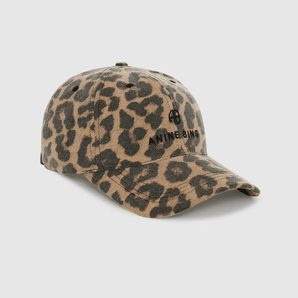 The Jeremy Leopard Baseball Cap by Anine Bing features a leopard print design with a curved brim and the brand's logo embroidered on the front. It includes an adjustable back strap for a personalized fit and is shown against a plain white background.