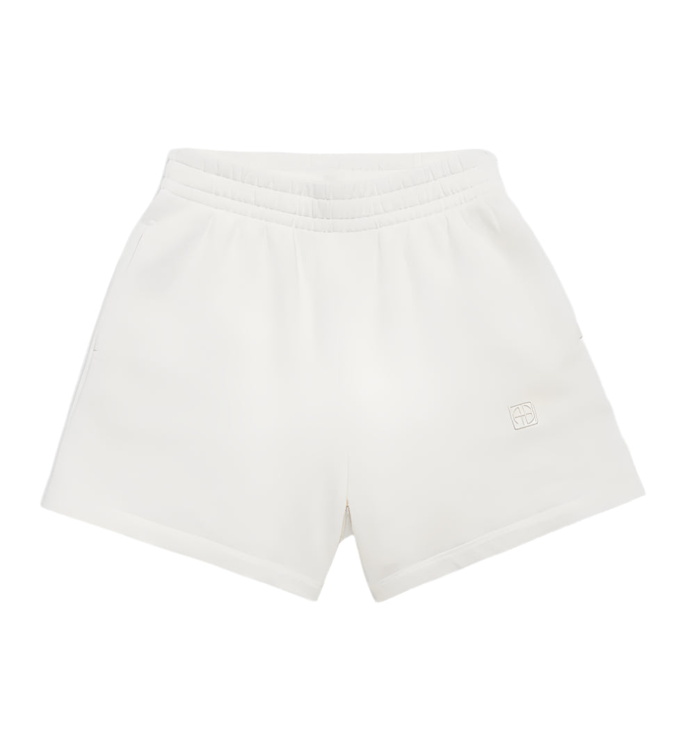 Anine Bing Kam Short Framed Monogram athletic shorts in soft midweight cotton feature an elastic waistband, side pockets, and a small embroidered logo on the lower left leg, shown against a plain background.
