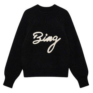 The Kendrick Sweater Bing by Anine Bing is a black alpaca-wool sweater with long sleeves and "Bing" in bold white script across the front, offering cozy style with signature AB branding.