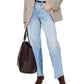 Person styles light-wash jeans with a front slit, a beige blazer, and brown pointed boots, carrying the Anine Bing Large Rio Tote—an essential accessory that adds chic style to any outfit.