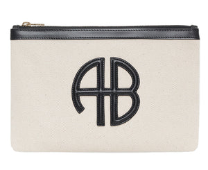 The Lili Canvas Pouch from Anine Bing is a beige cotton clutch with a black zipper and a black leather "AB" monogram on the front, inspired by the brand’s iconic Lili Bag.