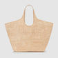 The Lili Raffia Tote by Anine Bing is a beige handwoven raffia bag featuring two handles, shown against a plain light background—an oversized tote that’s ideal for use as your everyday carryall.