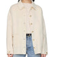 A woman wears the Anine Bing Luca Cashmere Blend Jacket in cream over a light sweater, styled with blue jeans.