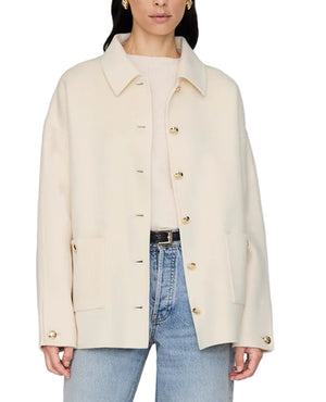 A woman wears the Anine Bing Luca Cashmere Blend Jacket in cream over a light sweater, styled with blue jeans.