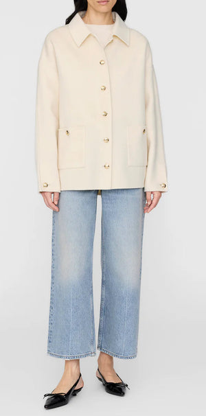 A person wears the Anine Bing Luca Cashmere Blend Jacket in cream, paired with light blue wide-leg jeans and black flats, standing against a plain background.