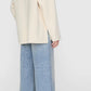 A person wearing the Anine Bing Luca Cashmere Blend Jacket, light blue wide-leg jeans, and black slingback flats stands against a plain background.