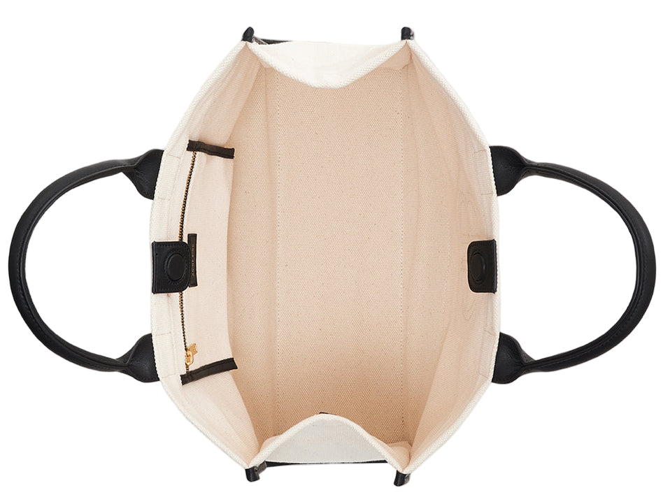 Top view of the Anine Bing Medium Lara Tote, an open cotton canvas bag with black handles and leather accents, featuring a roomy interior ideal for books, plus a zippered pocket and slip pocket inside.