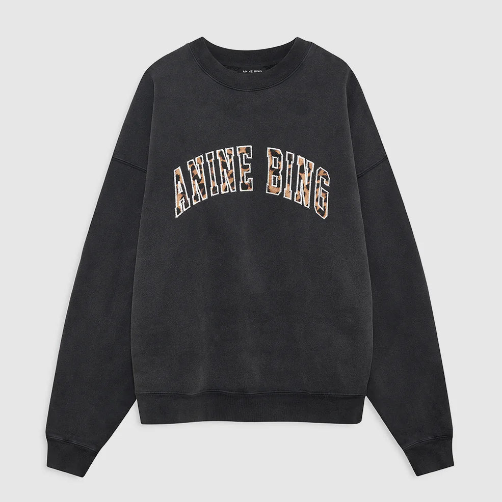Introducing the Miles Anine Bing Leopard Sweatshirt by Anine Bing—a black oversized sweatshirt made from organic cotton fleece, showcasing "ANINE BING" in bold, leopard-print block letters across the chest.
