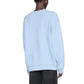 Model shown from the back against a white background, wearing the Anine Bing Miles Sweatshirt in pale blue with dark pants.