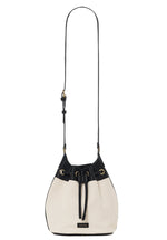The Mini Alana Bucket Bag by Anine Bing features a cream and black design, drawstring closure, gold-tone hardware, adjustable shoulder strap, and a small rectangular front label.