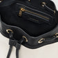 A close-up of the Mini Alana Bucket Bag’s interior reveals a black zippered pocket with gold-tone hardware and “Anine Bing” branding on the lining.