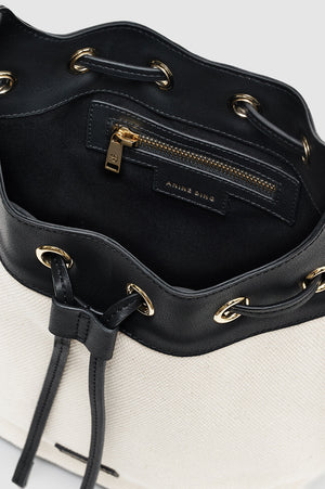 A close-up of the Mini Alana Bucket Bag’s interior reveals a black zippered pocket with gold-tone hardware and “Anine Bing” branding on the lining.