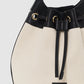 The Mini Alana Bucket Bag by Anine Bing features beige canvas, black leather trim, gold-tone hardware, a drawstring closure, adjustable strap, and "Anine Bing" label on the front.