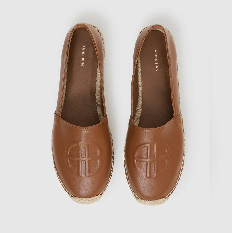 A pair of Paloma Espadrilles by Anine Bing, featuring stitched soles and embossed logos, crafted from leather and shown from above on a plain background.