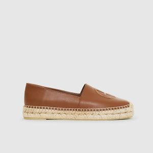 Anine Bing’s Paloma Espadrilles feature brown leather, a flat jute sole, and visible stitching, shown in a side view against a light background. Embrace effortless style with this chic design.