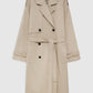 The Rickie Maxi Trench by Anine Bing is a beige cotton-twill, menswear-inspired double-breasted coat with a waist belt, epaulets, and buttoned cuffs, shown against a white background.