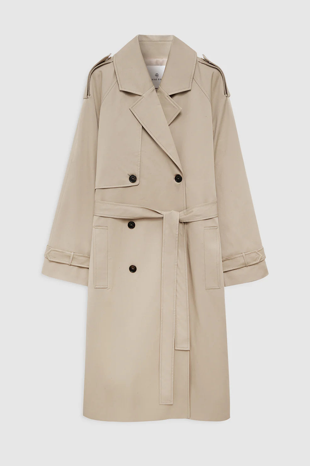 The Rickie Maxi Trench by Anine Bing is a beige cotton-twill, menswear-inspired double-breasted coat with a waist belt, epaulets, and buttoned cuffs, shown against a white background.