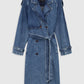 The Rickie Maxi Denim Trench by Anine Bing is a long-sleeved blue cotton denim coat featuring a notched collar, button front, waist belt, and adjustable cuffs, designed in a classic menswear-inspired silhouette and shown against a plain background.