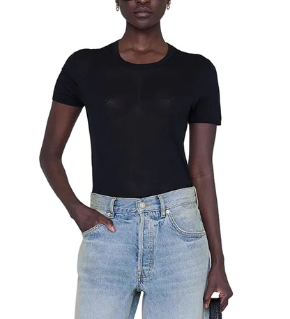 Model wearing the Anine Bing Sylvie Tee, a fitted black super soft crewneck top, paired with light blue high-waisted jeans, standing against a white background.