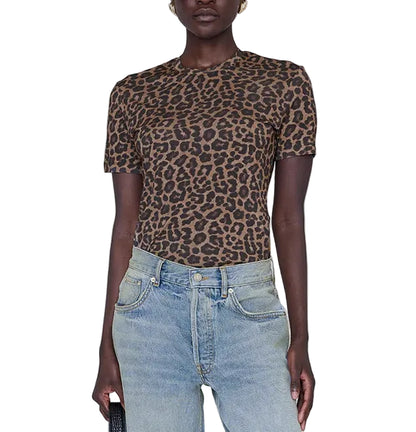 Wearing the ANB Sylvie Tee by Anine Bing—a short-sleeve, brown and black leopard print crewneck made from super soft, sheer jersey fabric—paired with light blue jeans, the person stands against a white background.