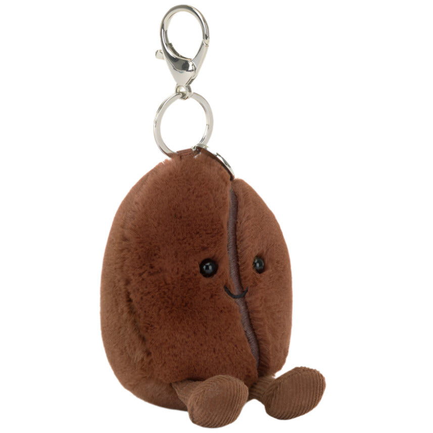 The Jellycat Amuseables Coffee Bean Bag Charm is a plush keychain with a smiling coffee bean design, small legs, black eyes, and a metal clip—perfect as a cute bag accessory.