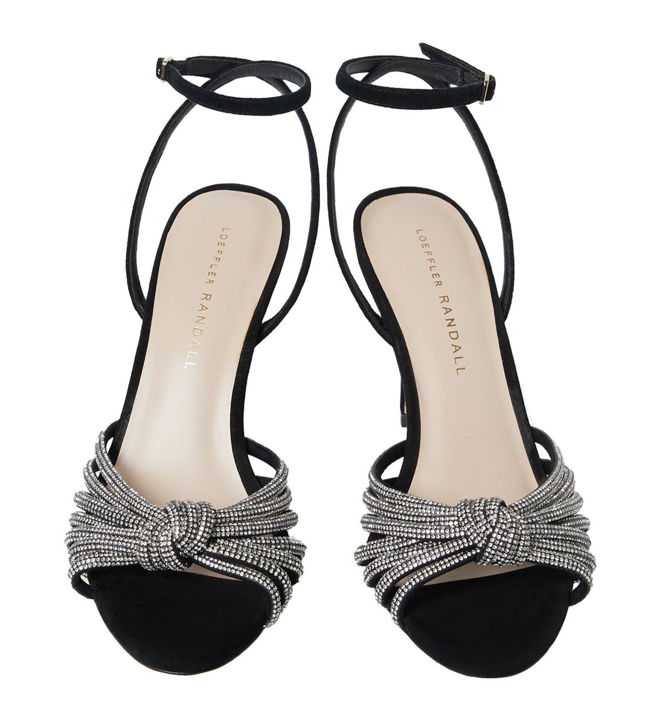 A pair of Loeffler Randall Ada Black Knot Heeled Sandals, featuring black suede straps embellished with rhinestones and the brand name "Loeffler Randall" printed on the insoles.