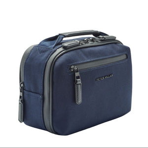 The Peter Millar Pursuit Travel Kit is a navy blue zippered toiletry bag with a front pocket, top handle, and genuine leather trim—perfect for travel or pairing with your Pursuit luggage.