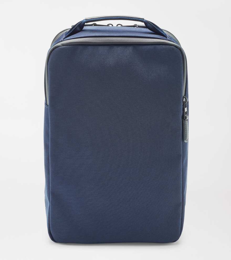 The Peter Millar Pursuit Shoe Bag is a navy blue rectangular travel bag with genuine leather trim, a top handle, and front zipper pocket, featuring a minimal design. Photographed against a plain white background.