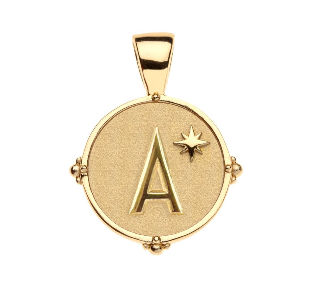 The Jane Win Letter Pendant Satellite Necklace Collection features a 14k gold pendant with a raised "A" and star on a textured round background, paired with a beaded satellite chain for personalized style.
