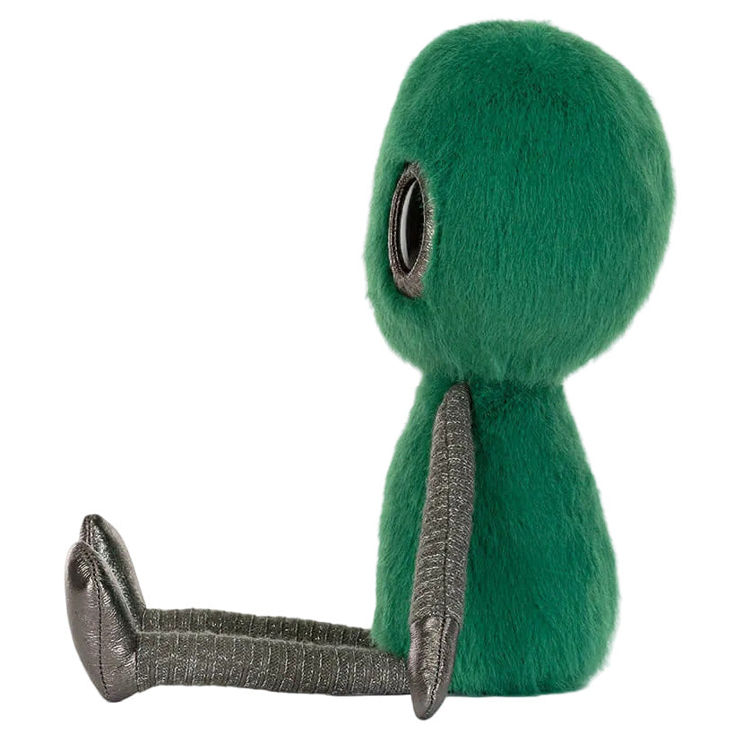 The Jellycat Zyllan Alien plush toy features a round galactic green fuzzy body, big black eye, and shiny silver arms and legs, sitting upright and facing sideways.